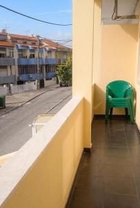 a green chair sitting on the side of a building at Comfortable Apartment in Feijó with Shared Pool, 90 m² in Almada