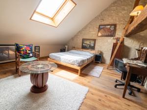 a bedroom with a bed and a table and a piano at Appartement spacieux à Chenevrey-et-Morogne 160 m² avec terrasse in Chenevrey-et-Morogne