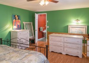 a bedroom with a bed and a dresser and a mirror at Cosy lakeside chalet in Mashteuiatsh with jacuzzi in Mashteuiatsh