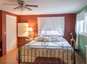 a bedroom with a bed and a ceiling fan at Cosy lakeside chalet in Mashteuiatsh with jacuzzi in Mashteuiatsh