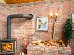 a brick wall with a fireplace and a pile of logs at Cosy lakeside chalet in Mashteuiatsh with jacuzzi in Mashteuiatsh