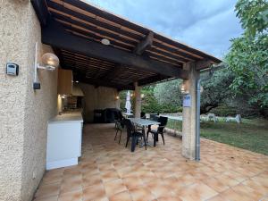 a patio with a table and chairs under a wooden pergola at Studio cosy tout confort proche ARKEMA in Château-Arnoux-Saint-Auban