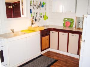 a kitchen with white cabinets and a sink at Maison charmante Deshaie + Vue in Deshaies