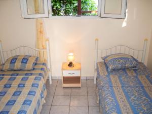 two twin beds in a room with a window at Maison charmante Deshaie + Vue in Deshaies