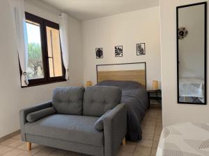 a living room with a couch and a bed at Studio cosy tout confort proche ARKEMA in Château-Arnoux-Saint-Auban