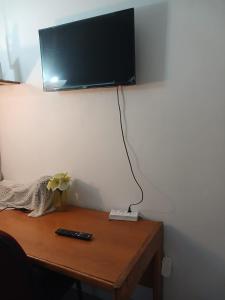 a television on a wall above a wooden table at LRN Brackenfell Homestay in Cape Town +80 photos