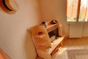 a living room with a tv on a shelf at Appartement avec piscine à Montpezat-de-Quercy 40 m² in Montpezat-de-Quercy +18 photos