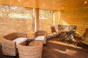 a screened in porch with wicker chairs and a table at Bungalow cosy à Saint-Leu, vue sur la mer. in Saint-Leu