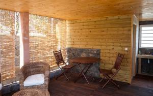 a porch with a table and chairs in a cabin at Bungalow cosy à Saint-Leu, vue sur la mer. in Saint-Leu