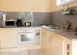 a kitchen with a sink and a microwave at Appartement confortable à Deshaies avec vue sur la mer - 55 m² in Deshaies