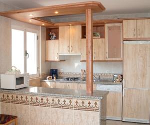 a kitchen with wooden cabinets and a white microwave at Charming Villa with Private Pool in La Calzada de Béjar in La Calzada de Béjar