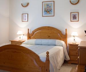 a bedroom with a wooden bed and two night stands at Charming Villa with Private Pool in La Calzada de Béjar in La Calzada de Béjar