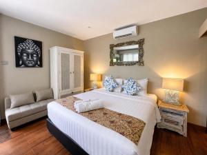 a bedroom with a large bed and a mirror at The Lodge Canggu in Tumbak Bayuh