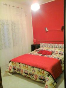 a bedroom with a bed with a red wall at Casa Poeta in Trapani