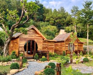 a log cabin in the middle of a garden at Sunny Camping Sóc Sơn in Sóc Sơn