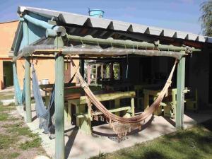 a picnic shelter with a hammock and a table at Hostel Lo de Milton in Barra de Valizas