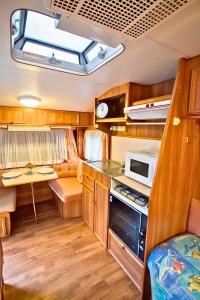 a kitchen in an rv with a stove and a microwave at Manilla Cottage - Manilla NSW in Manilla