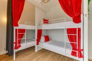 a bedroom with two bunk beds with red curtains at Avenue View Rooms in Porto