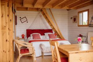 a bedroom with a bed in a wooden house at Cabane Pomme d'Amour in La Chapelle-Bouexic +36 photos