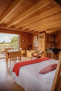 a bedroom with a bed and a table in a cabin at Cabane Pomme d'Amour in La Chapelle-Bouexic