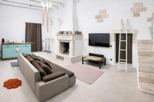 a living room with a couch and a fireplace at Lu Chiapparu - Vacanza Low Cost in Lequile