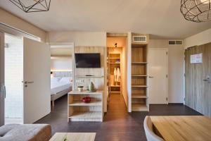 a living room with a bed and a room with a couch at Holiday Suites Zeebrugge in Zeebrugge +194 photos