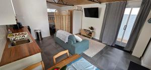 a living room with a blue couch and a kitchen at Studio in Quindalup bay in Quindalup +2 photos