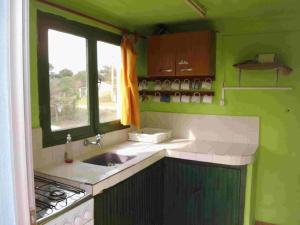 a green kitchen with a sink and a window at Hostel Lo de Milton in Barra de Valizas +111 photos