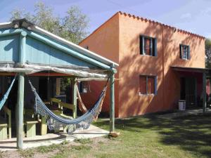 a house with a hammock in front of it at Hostel Lo de Milton in Barra de Valizas