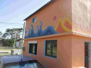 a building with a painting on the side of it at Hostel Lo de Milton in Barra de Valizas