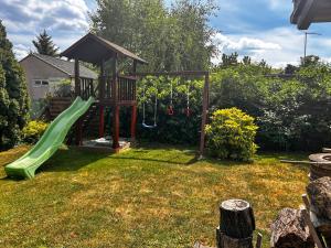 a playground with a green slide in a yard at Lily House in Balatonvilágos