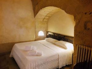 a bedroom with a white bed in a room at Cave Rooms Sassi in Matera +37 photos