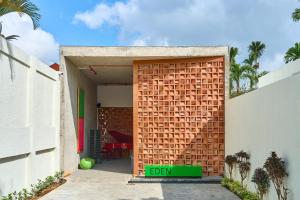 ajar door of a house with a brick wall at Hotel Eden Ubud in Ubud