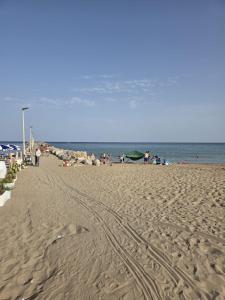 a group of people walking on the beach at Esmeralda Guest House in Cinisi