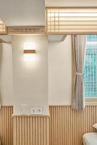 a bedroom with a window and a clock on the wall at ZIP 1972 DDP two-min from airport bus station 4-min from DDP subway station in Seoul +78 photos