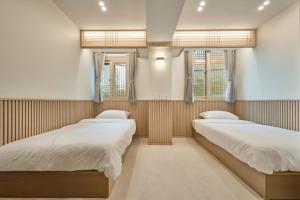 two beds in a room with two windows at ZIP 1972 DDP two-min from airport bus station 4-min from DDP subway station in Seoul