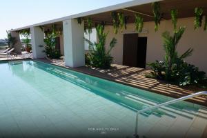 a swimming pool in front of a house at Hotel Brisamar Suites in Comarruga
