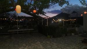 a park with a bench and lanterns at night at Apartmani Stanić in Sutomore