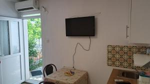 a room with a table and a television on the wall at Apartmani Stanić in Sutomore