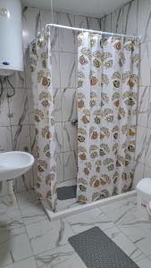 a bathroom with a shower curtain with a monkey pattern at Apartmani Stanić in Sutomore +17 photos