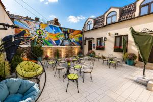 a patio with tables and chairs in front of a mural at City SMART in Niš
