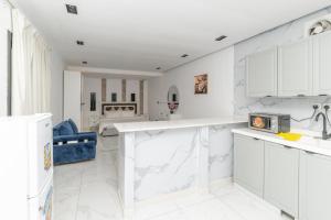 a kitchen with white marble countertops and a blue couch at Jeddah Apartment in Jeddah