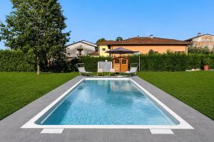 a swimming pool in a yard with chairs and a gazebo at Villa Angela in Capannori