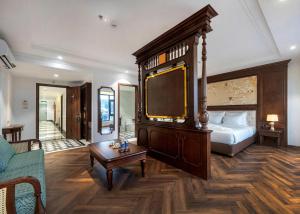 a bedroom with a bed and a tv and a table at Diamond Hotel Yen Bai in Yên Bái