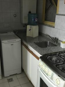 uma pequena cozinha com um lavatório e um fogão em Departamento en Nueva Cordoba em Córdova