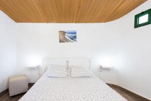 a bedroom with a white bed and a wooden ceiling at TenoHomes La Era de Catuja Getaway in Los Realejos