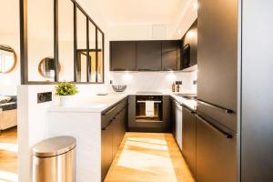 a kitchen with black cabinets and white countertops at Black and White - Joli appart à Tours in Joué-lès-Tours