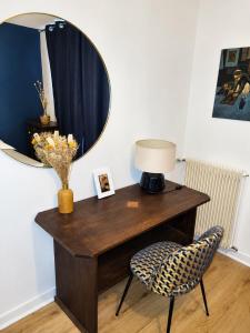 a desk with a lamp and a chair with a mirror at Black and White - Joli appart à Tours in Joué-lès-Tours +4 photos
