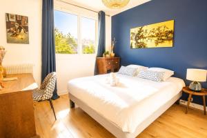a bedroom with a large bed with a blue wall at Black and White - Joli appart à Tours in Joué-lès-Tours