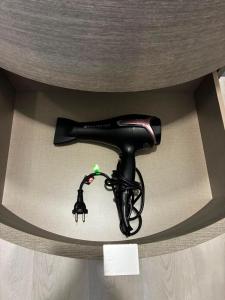 ein schwarzer Haartrockner in einer runden Schachtel in der Unterkunft Suite 13 in Pesaro